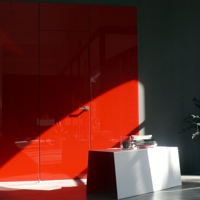 Revestimiento de pared en vidrio rojo brillo y puerta enrasada mismo acabado