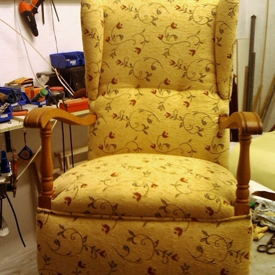 Sillón orejero con brazos de madera y balancín
