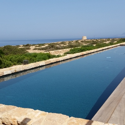 Piscina exterior en Baleares, de 24m x 4.50m desbordante oculto bajo tarima