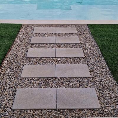 Diseño de exterior con piscina y camino decorativo en piedra natural