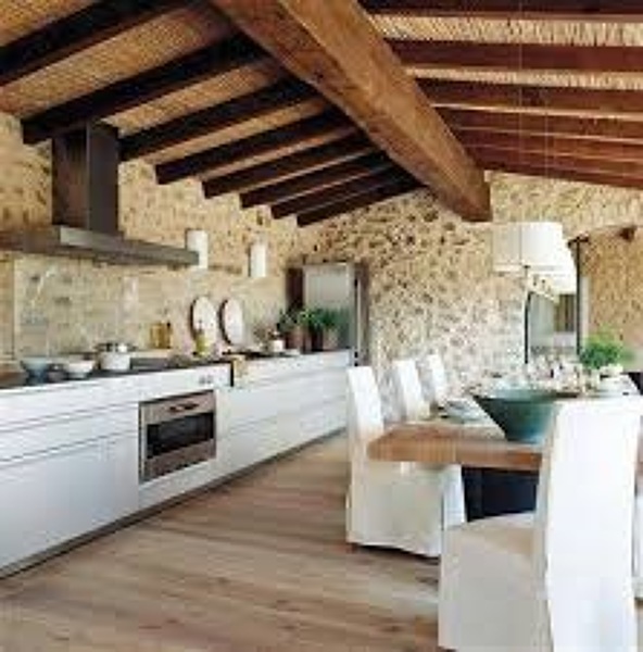 COCINA Reformada con piedra en paredes con vigas madera en el techo.