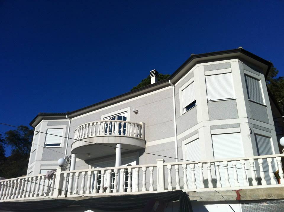 Canal pizarra con bajantes en blanco que se funden con la casa