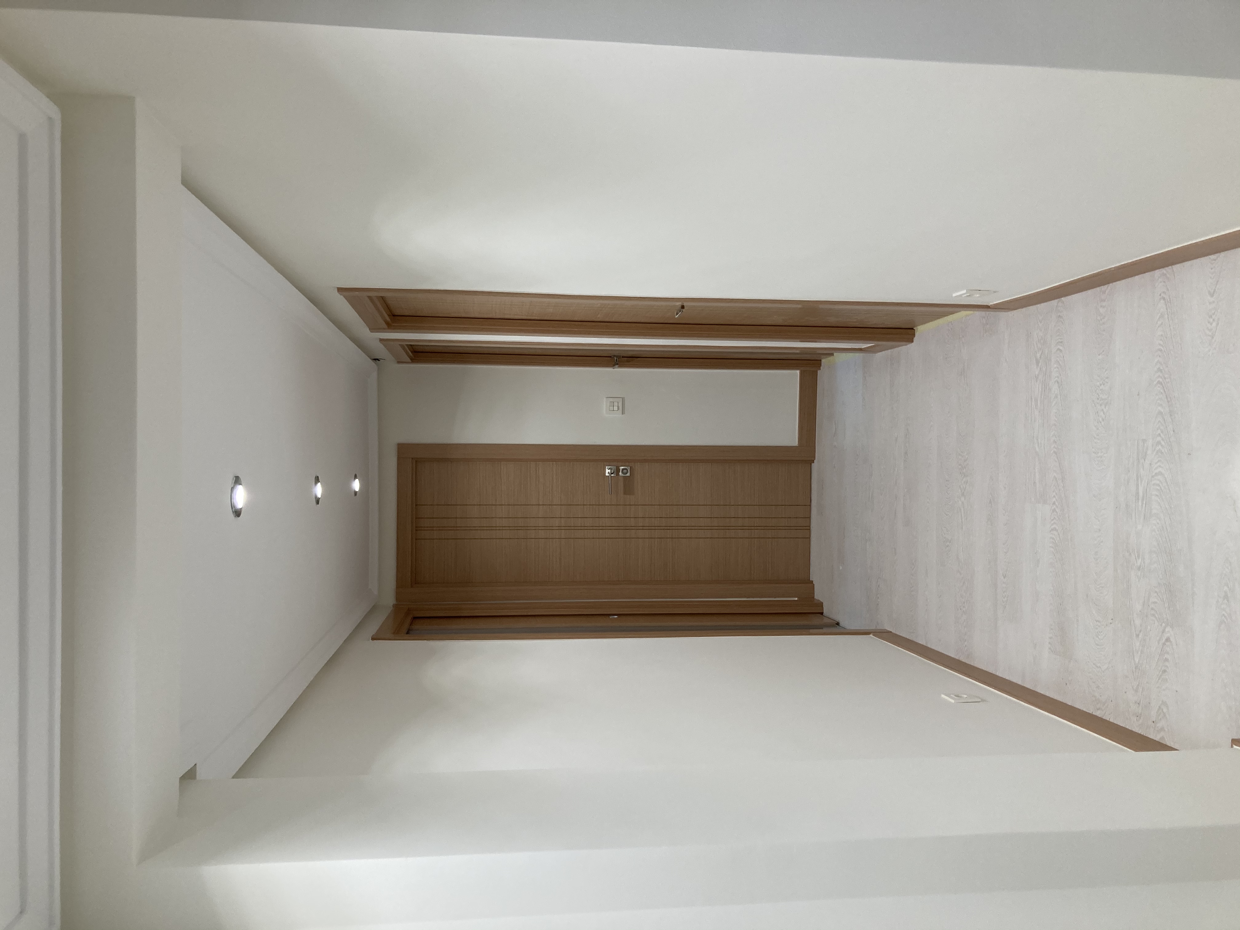 Suelo laminado en gris claro y puertas en color roble.