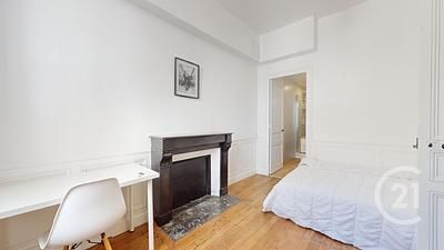 Dormitorio con chimenea y suelo madera natural