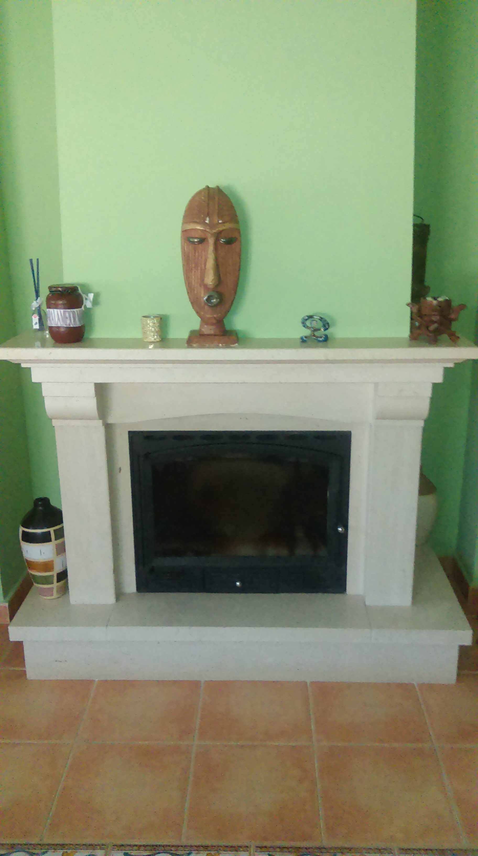 Chimenea de leña cerrada con cristal y mármol travertino.