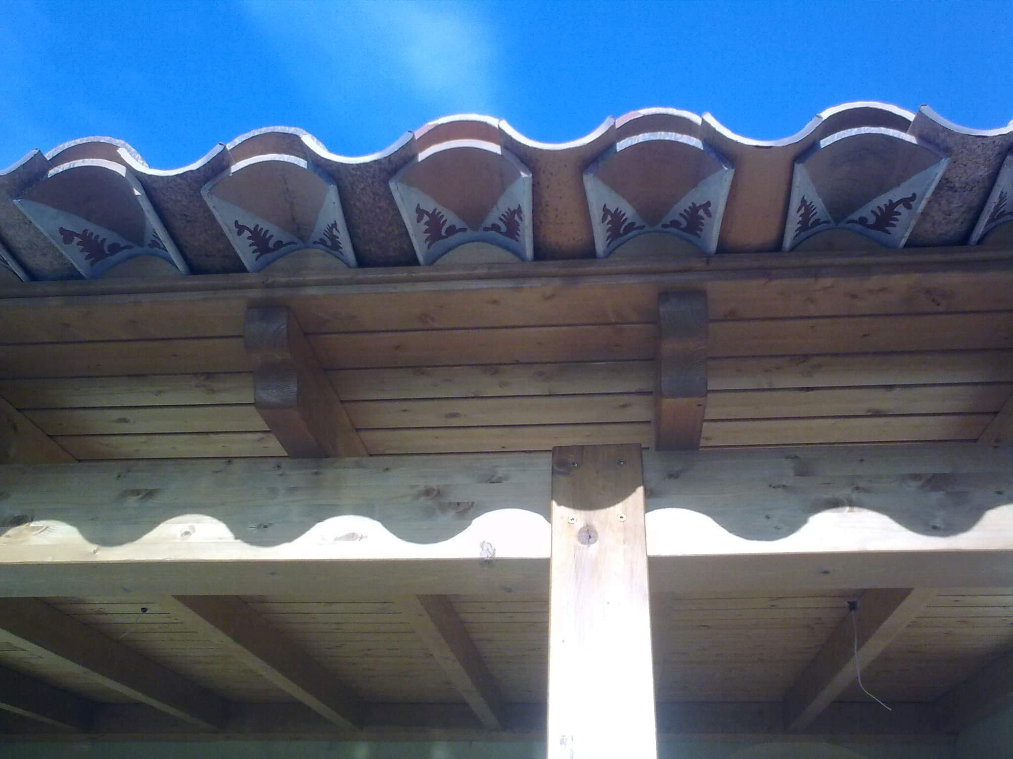 Detalle de alero con tejas decoradas.