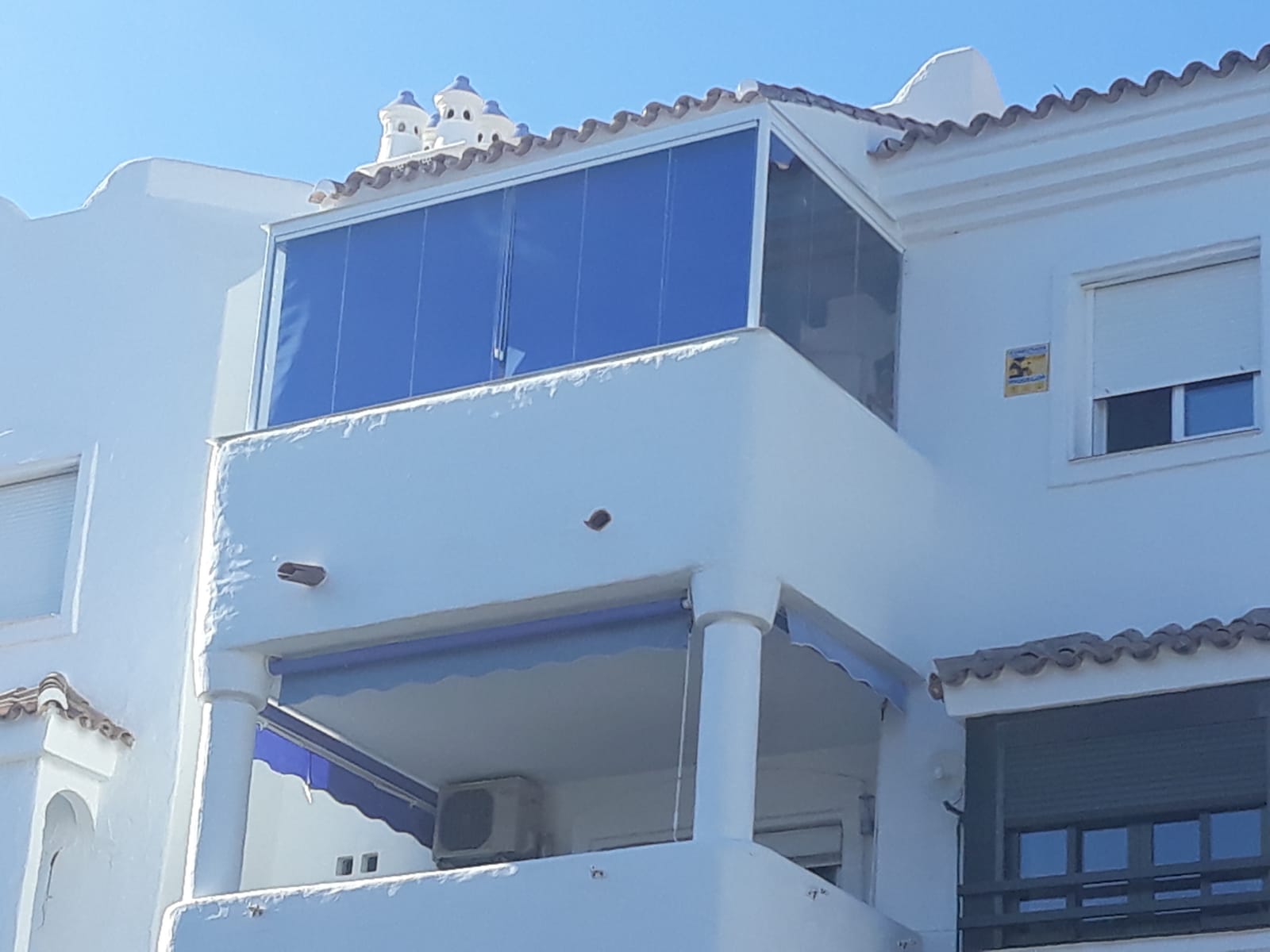 Balcón cerrado con cortinas de cristal