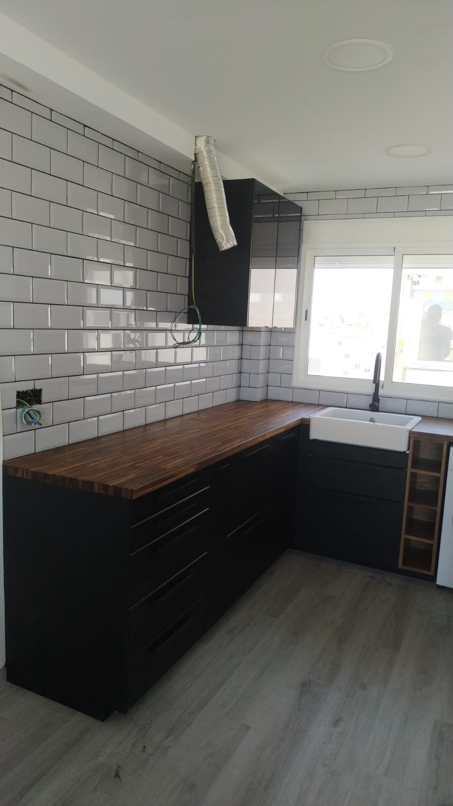 Cocina rústica con tonos negros, maderas y blancos para un ambiente cálido y acogedor