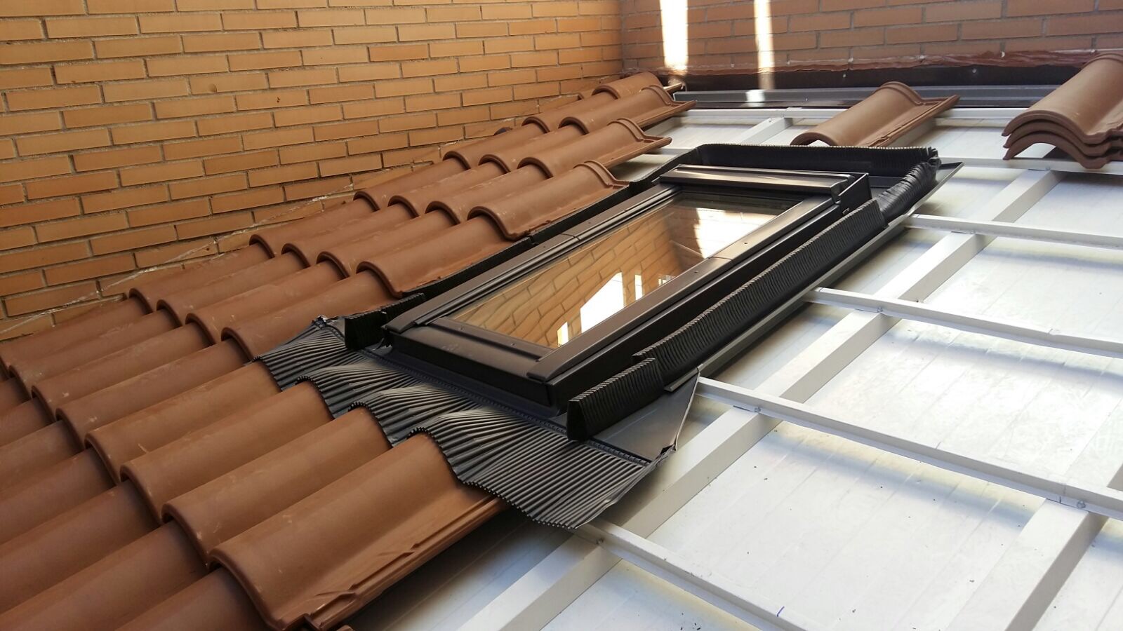 Techado de patio interior con panel sándwich y teja mixta.