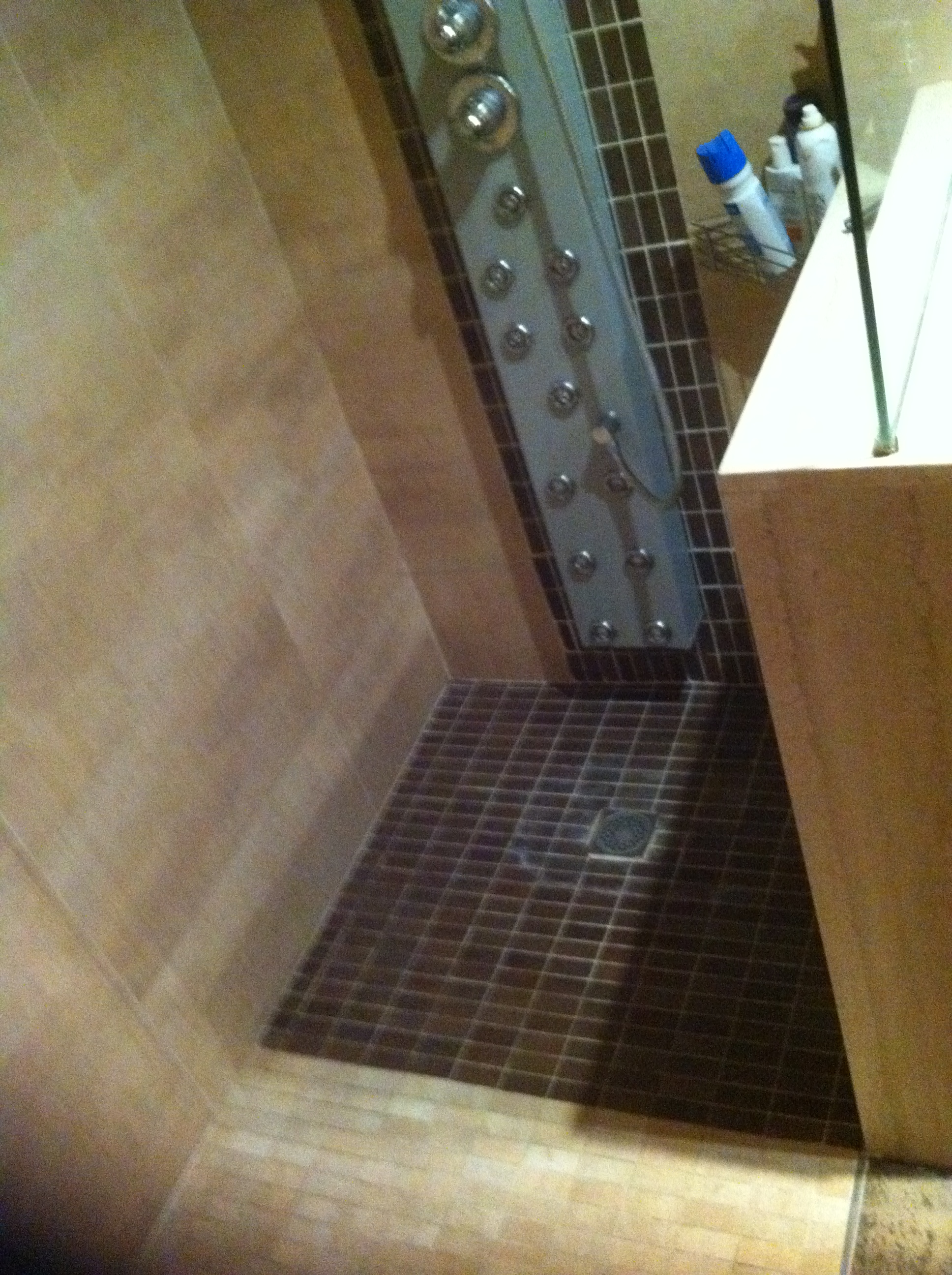 Plato de ducha de obra en grisite marón con piezas beis.