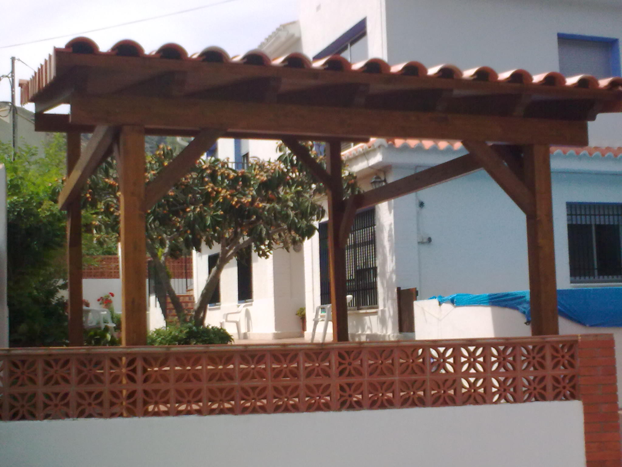 Porche de madera acabado con teja cerámica.