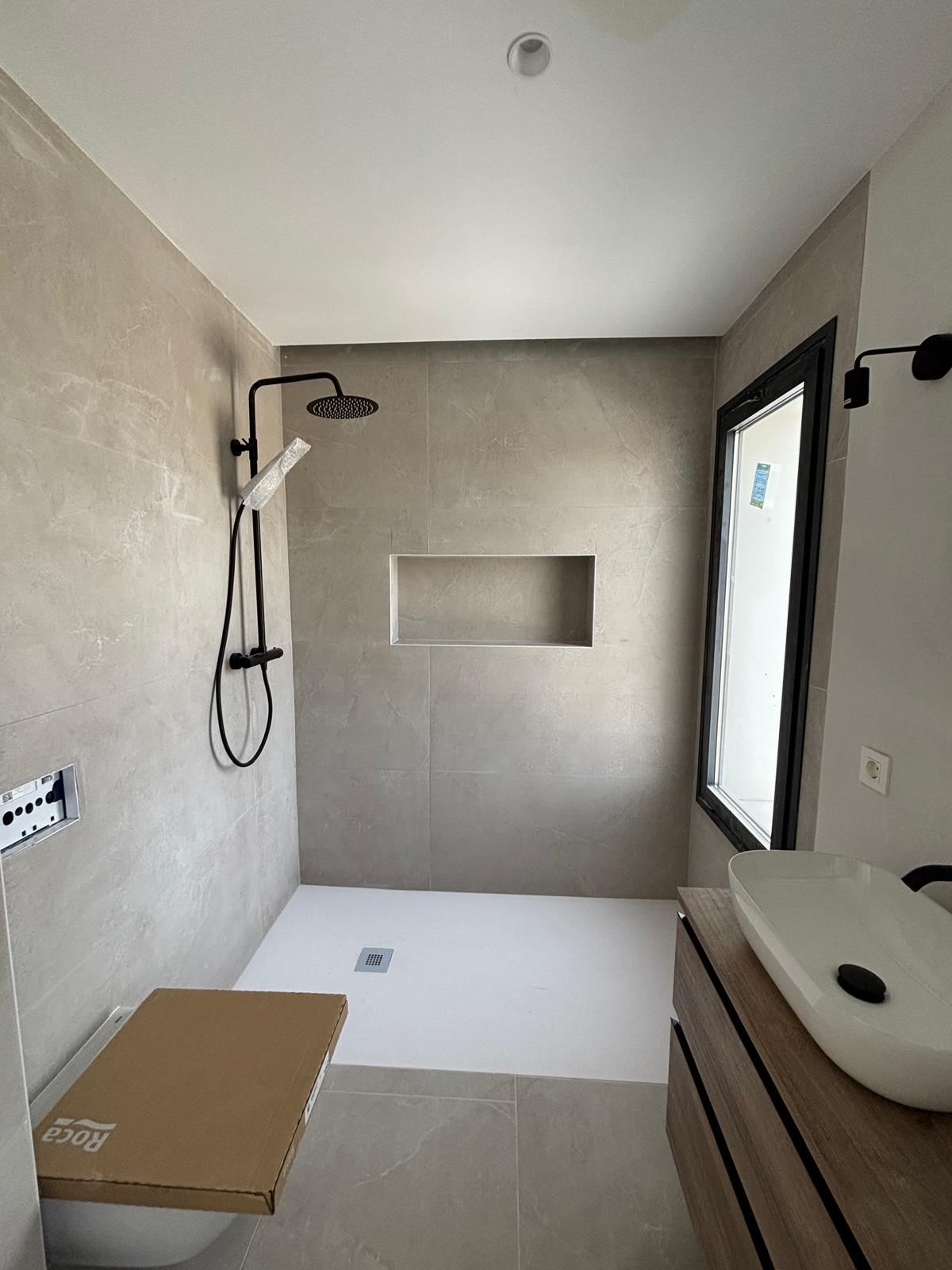 Baño moderno con plato de ducha a ras de suelo y hornacina integrada