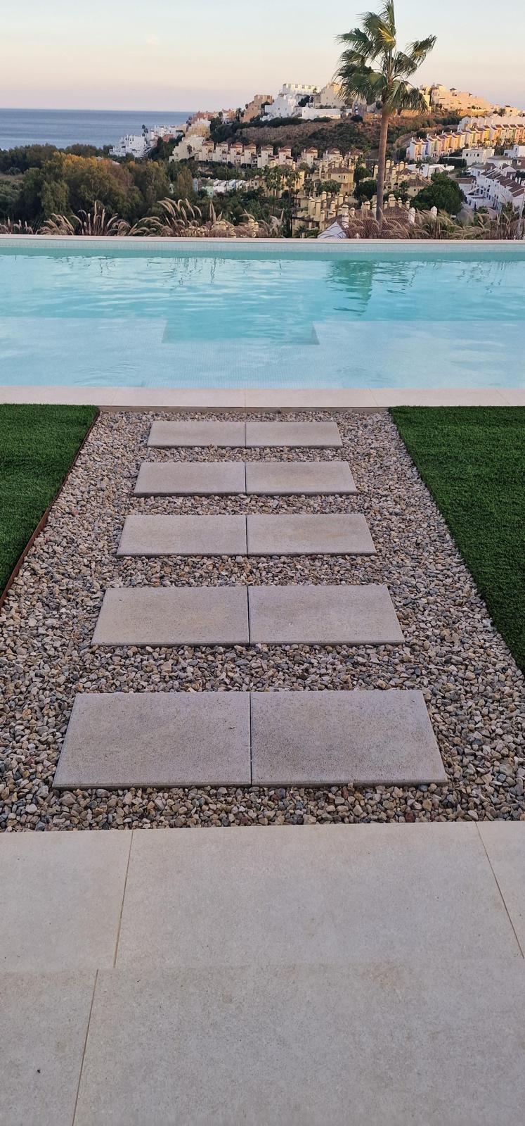 Diseño de exterior con piscina y camino decorativo en piedra natural