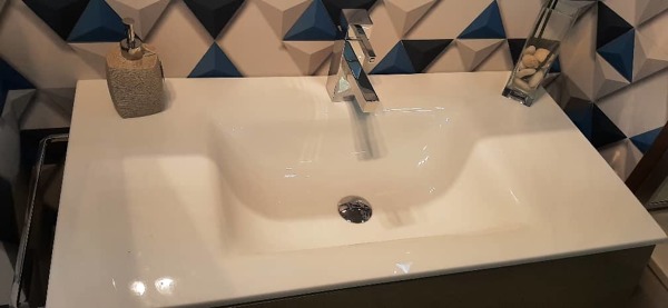 Lavabo sobre encimera de porcelánico.