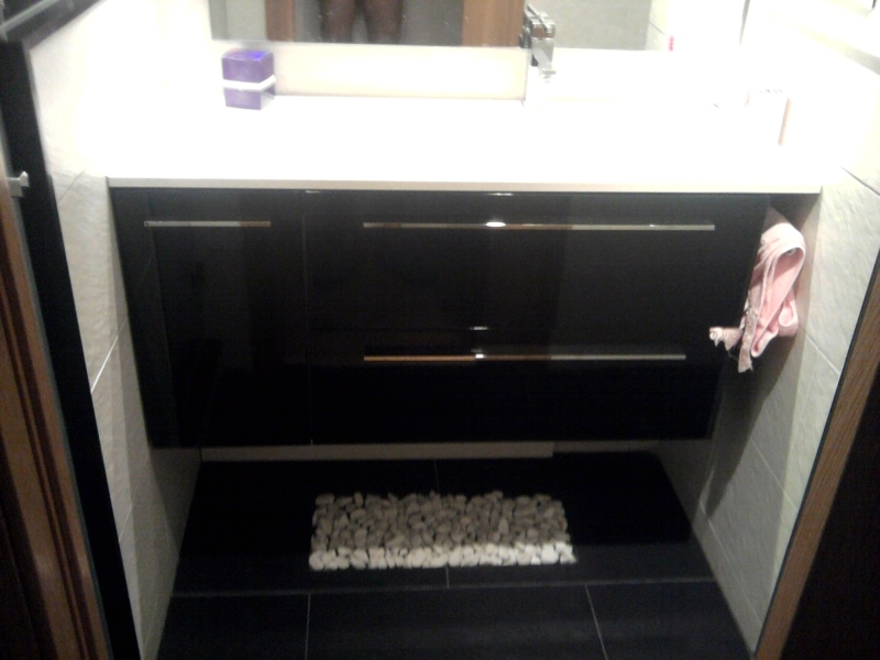 Mueble alto de un lavabo lateral y piedras decorativas bajo mueble