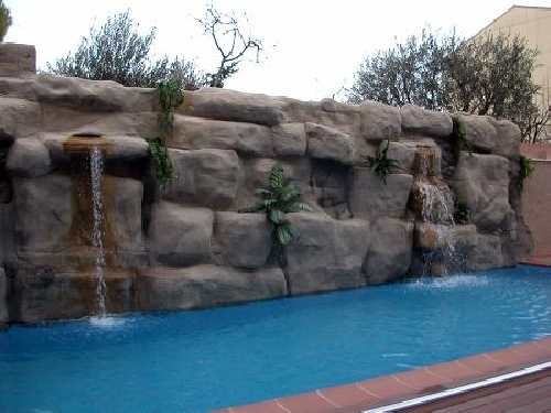 Piscina alargada con casacada para relajarte.