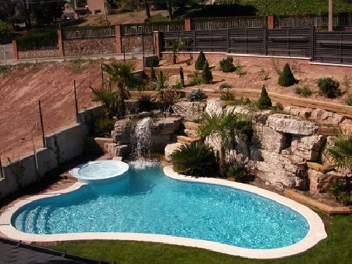 Piscina equipada con cascada y spa