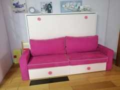 Cama abatible horizontal con sofá delante.