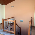 Buhardilla con escaleras de madera torneada y acero inoxidable
