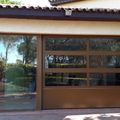 Puerta seccional con perfileria de aluminio y doble vidrio con fijo adosado. www.puertasmaemar.es