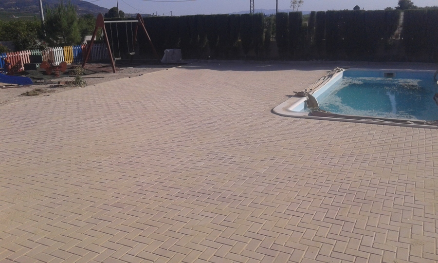 Adoquín colocado rededor de piscina en espiga