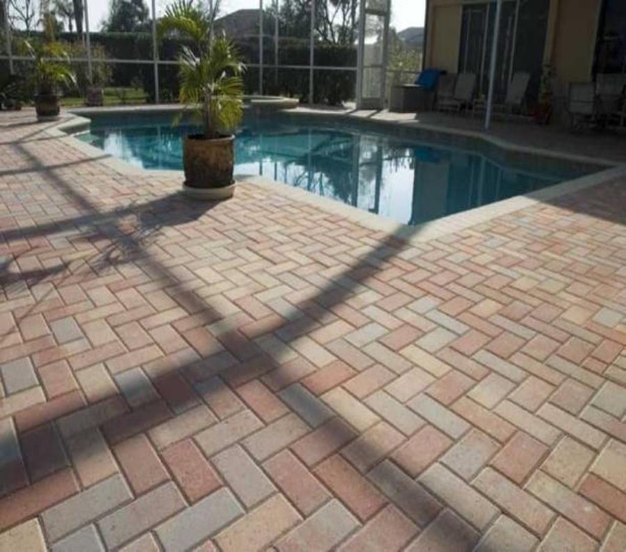 Adoquín tricolor en rededor de piscina en espiga