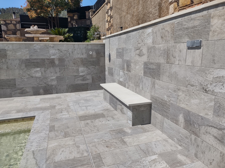 Banco auxiliar y zona de ducha con pulsador.