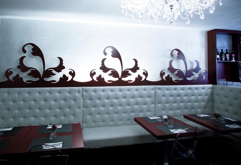 Banco corrido con madera lacada y tapizado capitoné.