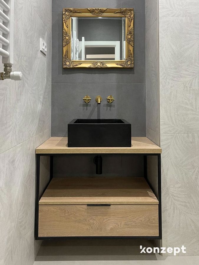 baño alicatado gris y grifería dorada