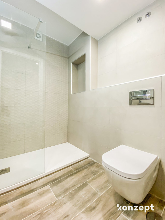 Baño con hornacina de obra, inodoro suspendido y cisterna empotrada