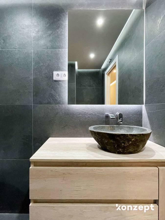 Baño con iluminación led y lavabo de piedra