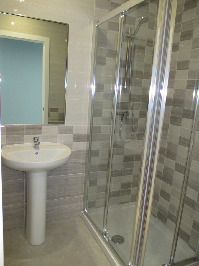 Baño en Sala 1 con ducha y espejo encastrado en pared