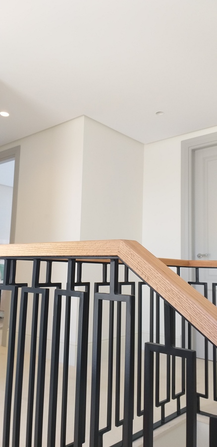 Barandilla en esmalte negro con pasamanos lacado natural.