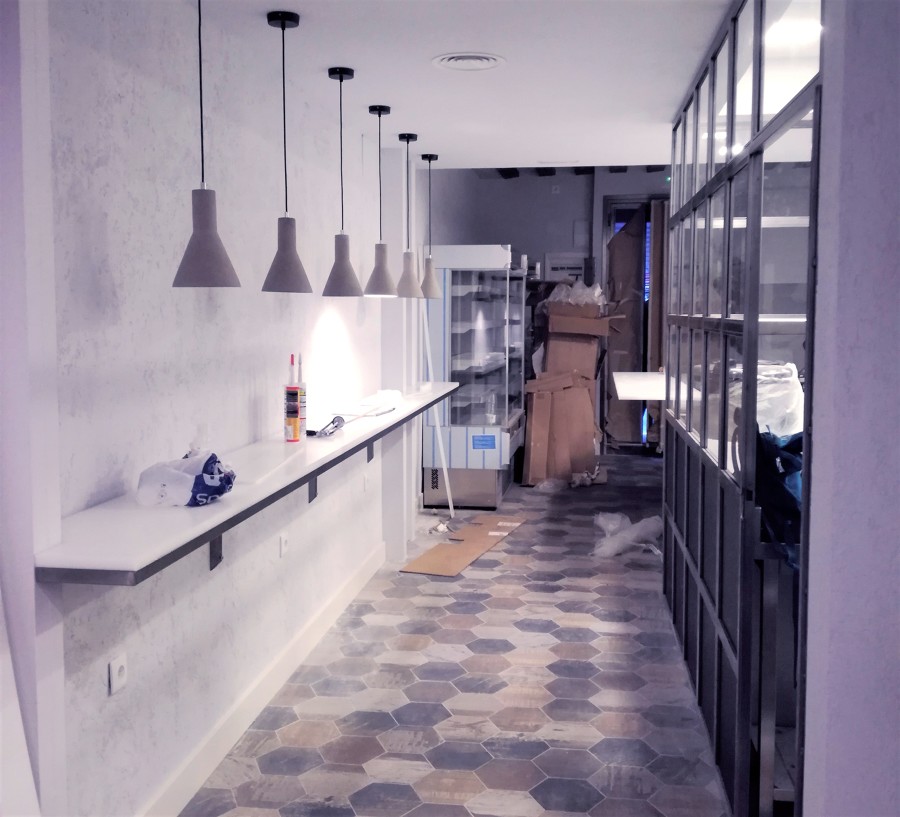 Barra con iluminación individual y pared de cristal durante la reforma