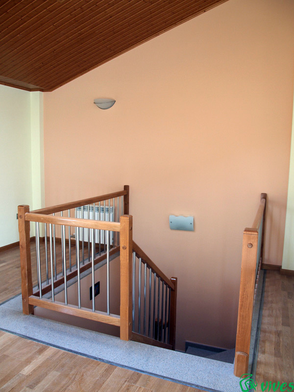 Buhardilla con escaleras de madera torneada y acero inoxidable
