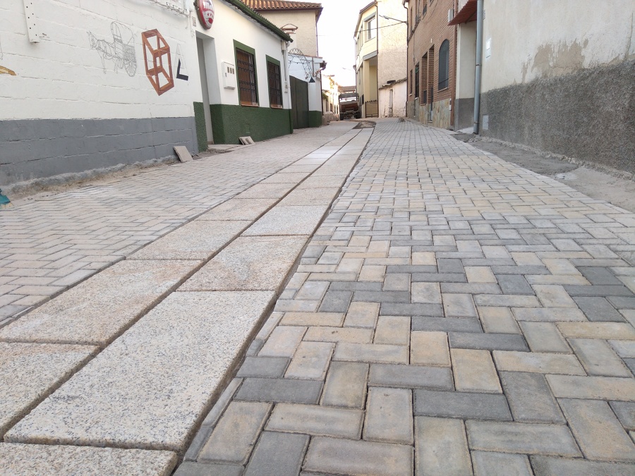 Calle pavimentada con adoquines y aceras de piedra