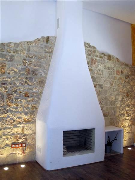 Chimenea terminada con pared de piedra e iluminación