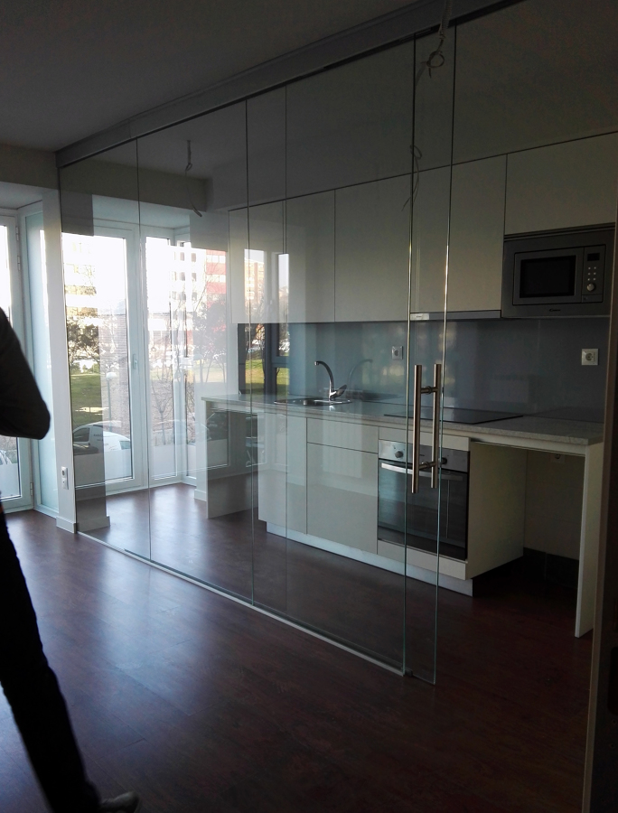 Cocina integrada en salón con mampara de vidrio