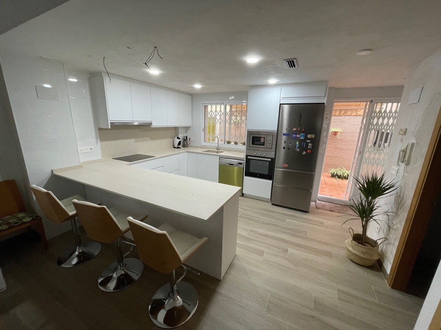 Cocina con península y barra americana.