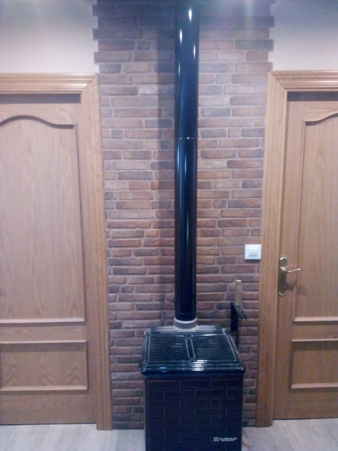 Colocacion de estufa de leña y carbon con ceramica porcelanico detras.