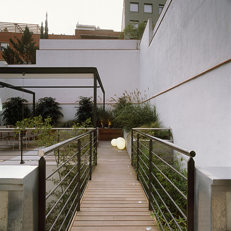 Conexión: Pasarela en madera Ipa conduce a la terraza superior desde la casa.