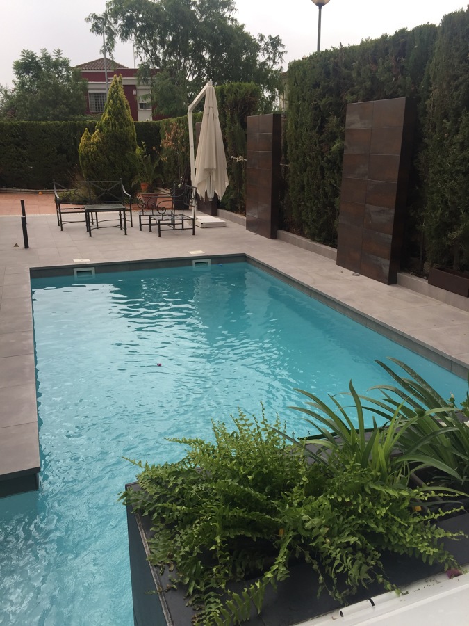 Depuradora Zodiac elevada detrás de cascada