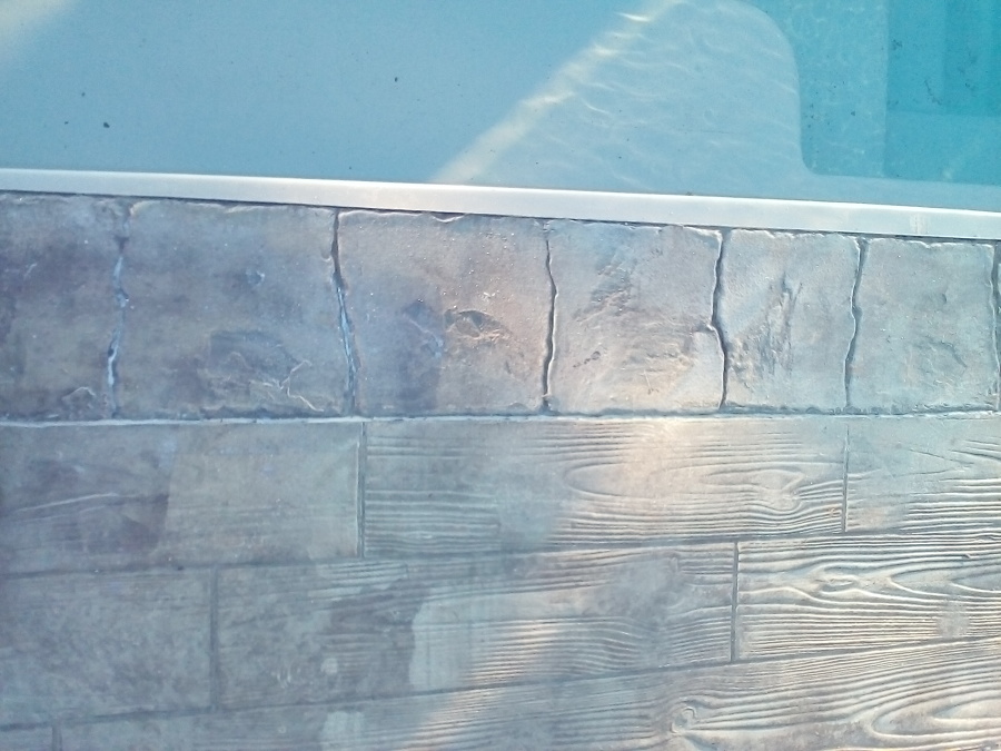 Detalle borde piscina con remate aluminio y piedra impresa
