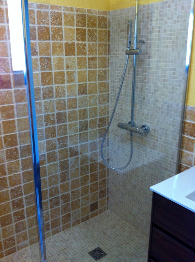 Detalle cristal fijo y ducha de obra