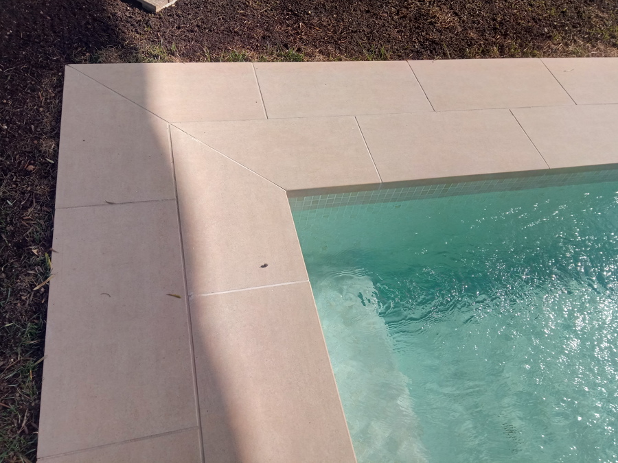 Detalle de la esquina coronada con porcelánico beige.