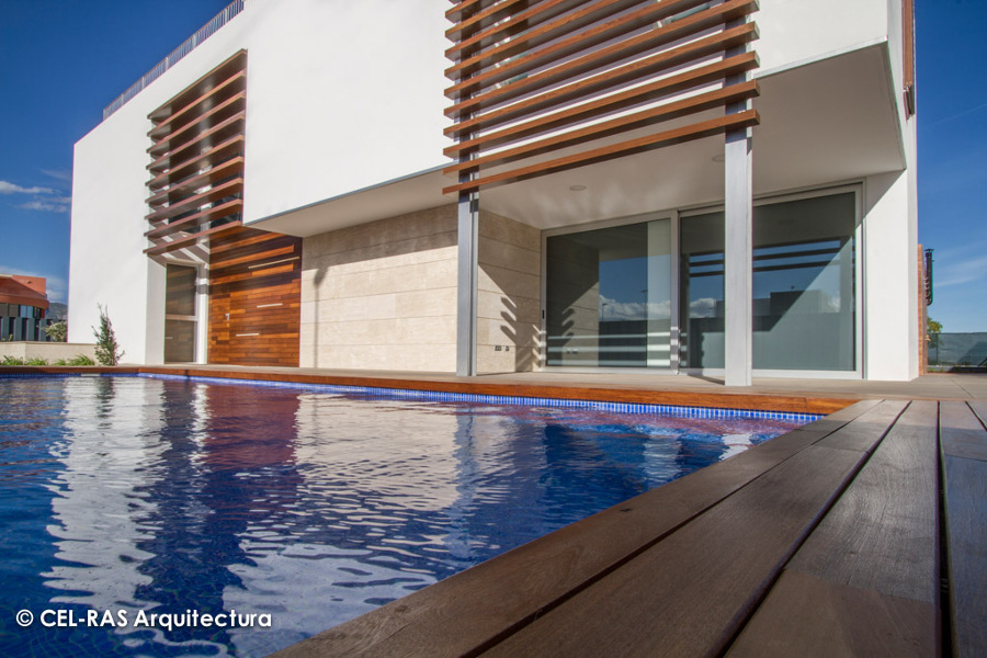 Detalle de la tarima de madera que bordea la piscina y las lamas que conforman la celosía
