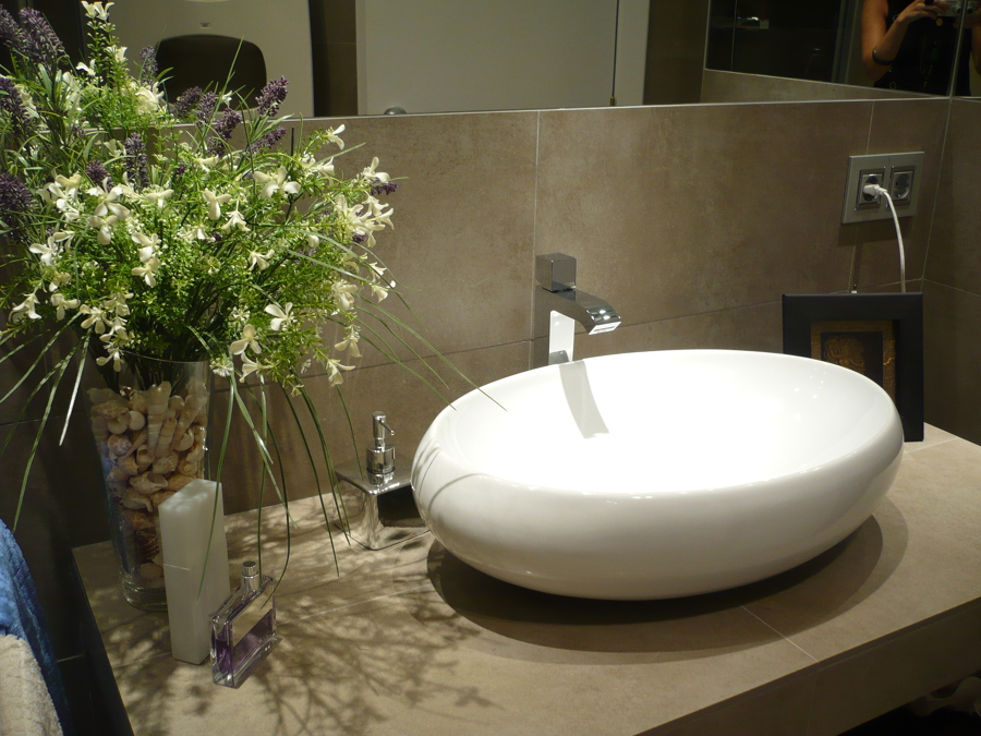 detalle de lavabo sobre encimera de obra volada a medida y revestida mismo material paredes