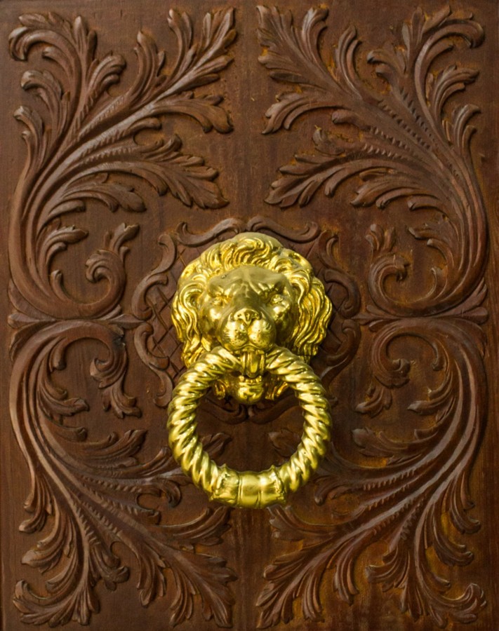 Detalle de puerta con llamador en dorado