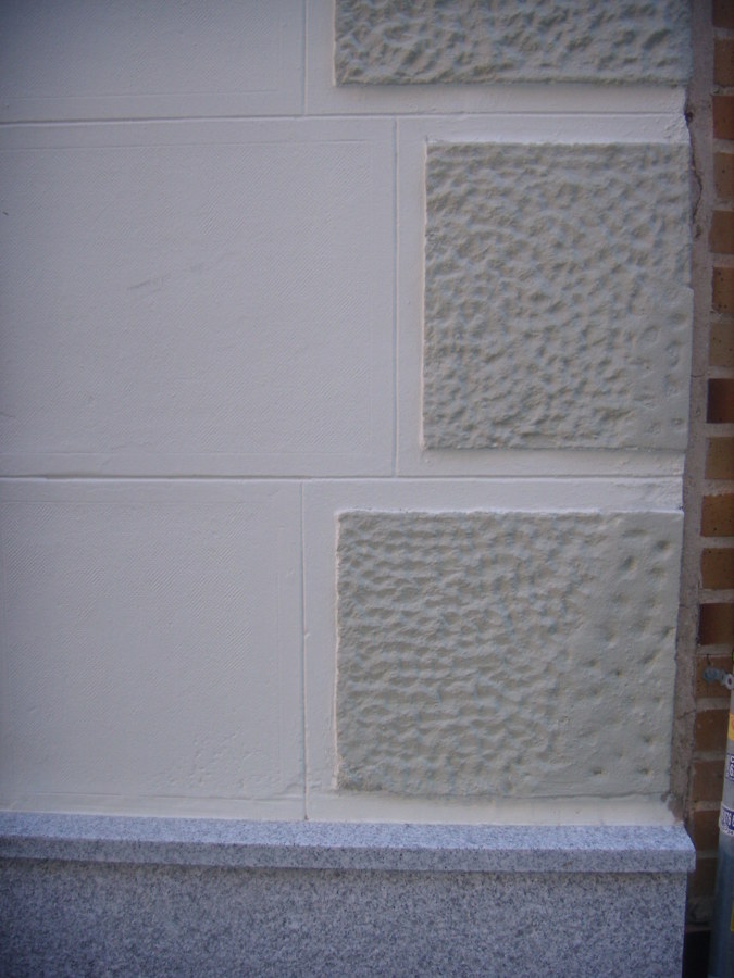 Detalle del nuevo zócalo de granito y de la restauración de la fachada