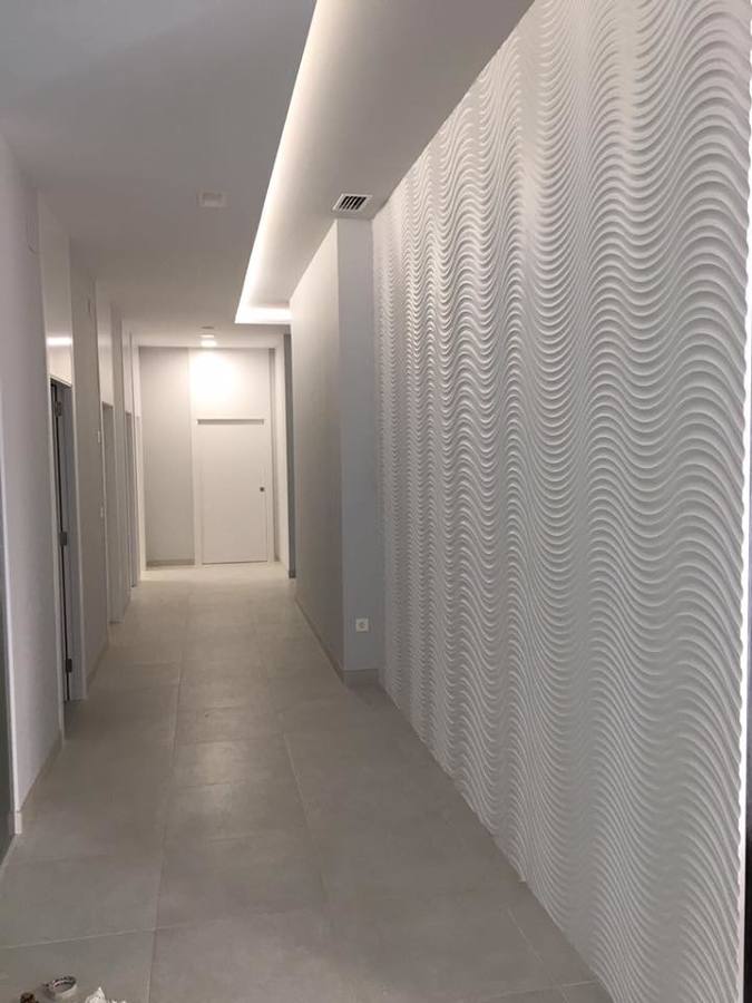 Distribuidor con panelado en madera lacada y luz indirecta